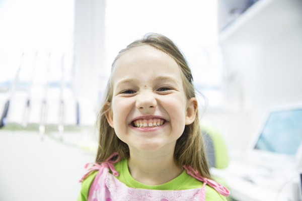 Little girl with big smile in dental chair, at Arlington Pediatric Dentistry in Arlington, WA. 