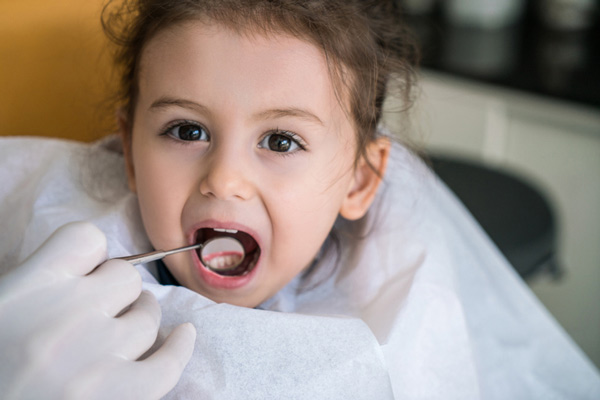 Dentist examining little girl's teeth.